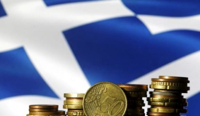Euro coins are seen in front of a displayed Greece flag in this picture illustration