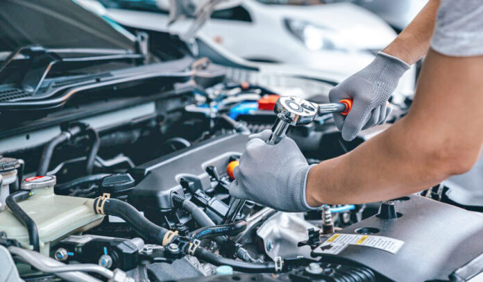 Mechanic,Using,Wrench,While,Working,On,Car,Engine,At,Garage